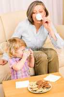Little girl with grandmother eat cookies