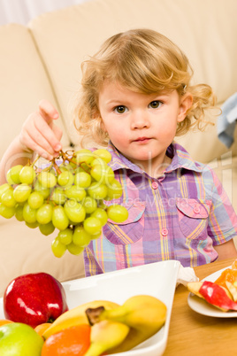 Cute little girl hold grapes fruit bowl