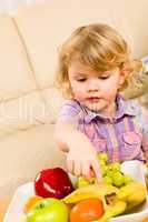 Little girl wants fruit pointing at banana