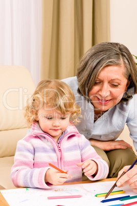 Little girl with grandmother drawing together