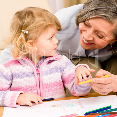 Little girl with grandmother drawing together