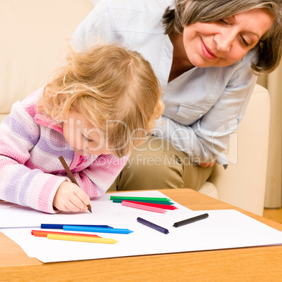 Grandmother and granddaughter drawing at home