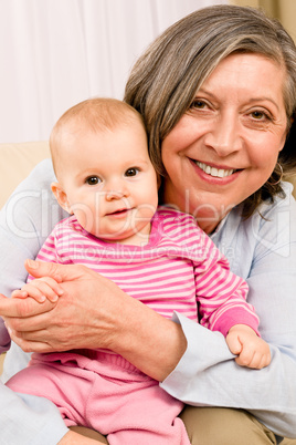 Grandmother hold little baby girl smiling