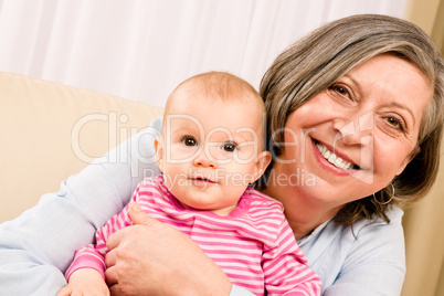 Grandmother hold little baby girl smiling