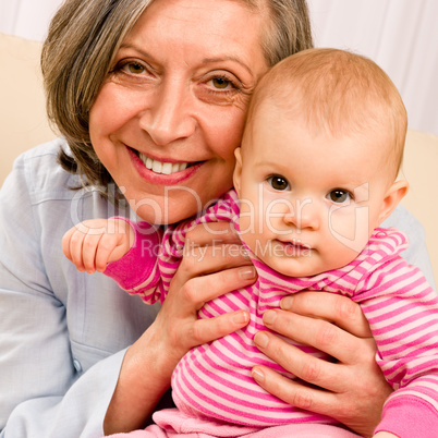 Grandmother hold little baby girl smiling