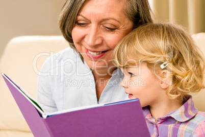 Grandmother and granddaughter read book together