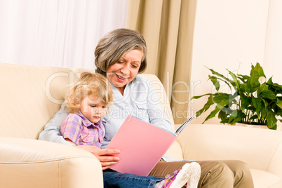 Grandmother and granddaughter read book together