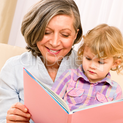 Grandmother and granddaughter read book together