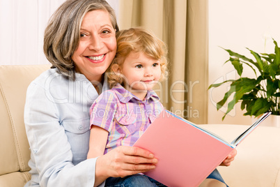 Grandmother and granddaughter read book together