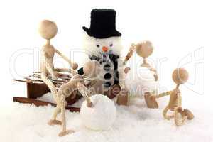 Familie mit Kindern baut einen Schneemann