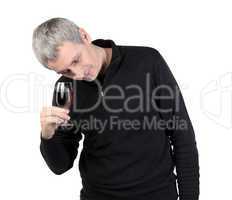 Man looks at a glass of red port wine