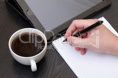 Closeup of a male hand writing notes on notepad