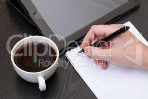 Closeup of a male hand writing notes on notepad
