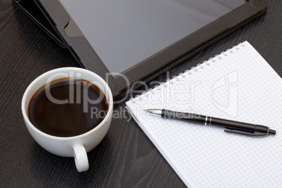 Coffee cup, tablet, spiral notebook and pen