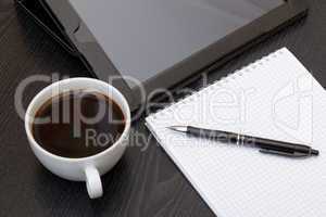 Coffee cup, tablet, spiral notebook and pen