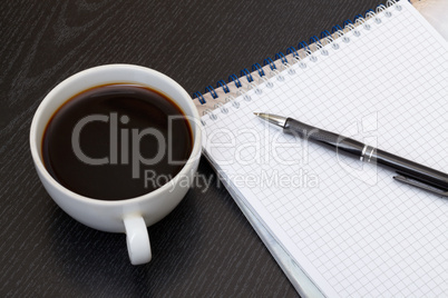 Coffee cup, spiral notebook and pen