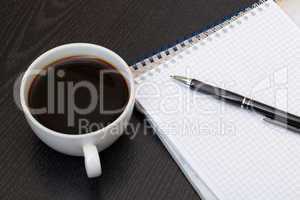 Coffee cup, spiral notebook and pen