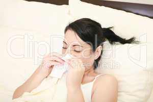 Closeup of gorgeous caucasian woman with cold sneezing into tiss