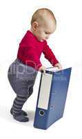 small child standing next to blue ring binder