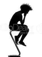 young afro american woman silhouette sitting on footstool thinki