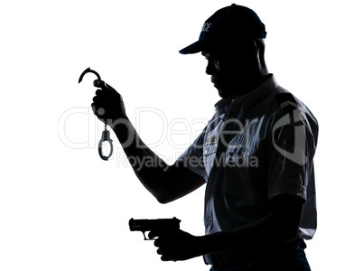 Policeman holding handcuffs and handgun