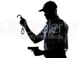 Policeman holding handcuffs and handgun