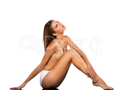 Topless beautiful woman sitting on floor full length