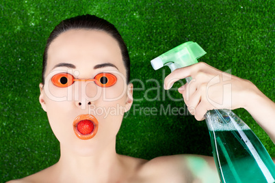 Woman wearing tanning bed glasses with strawberry in mouth and s