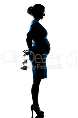 pregnant woman holding baby shoes