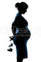 pregnant woman portrait holding baby shoes