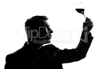 silhouette man tasting  looking at his glass of red wine