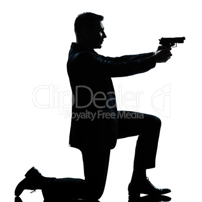 silhouette man kneeling aiming gun