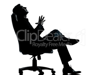 one business man sitting in armchair relaxing thinking silhouett