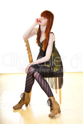 Frau im eleganten Kleid sitzt gelangweilt auf dem Stuhl
