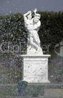 Statue in einem Barockgarten hinter einer Fontäne