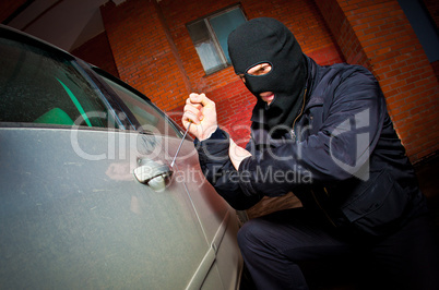 robber and the thief in a mask hijacks the car