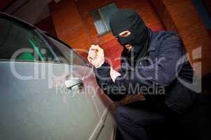 robber and the thief in a mask hijacks the car