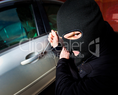 robber and the thief in a mask hijacks the car