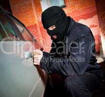 robber and the thief in a mask hijacks the car