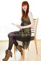Frau mit Buch sitzt auf dem Stuhl