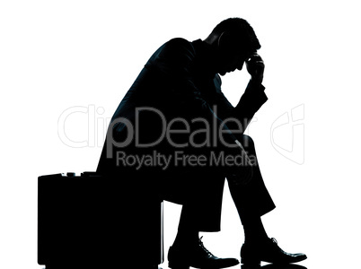 one business man sitting on suitcase tired despair silhouette