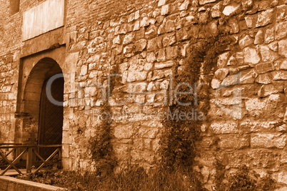 Medieval stone wall with an iron gate