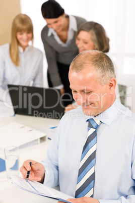 Happy businessman read report during team meeting