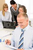 Happy businessman read report during team meeting
