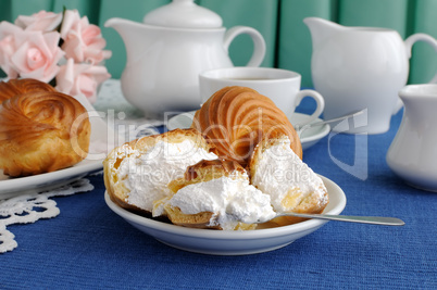 Eclairs close-up on a plate with a cup of coffee