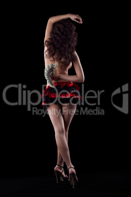 Striptease girl in red dance with money in dark
