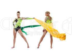 Two beauty gymnasts fight with flying fabric