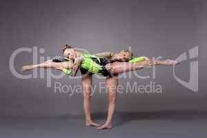 Two young woman as acrobats exercise pair program