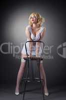 Sensuality gold blond woman stand with bar chair