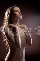 Young naked woman in dark with drops on body